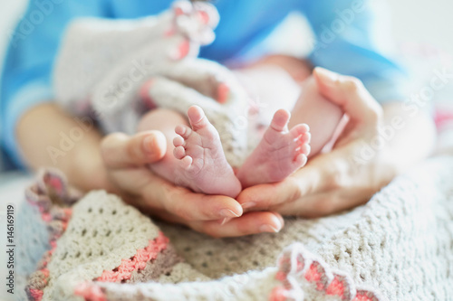 Mother holding newborn baby's feet in her hands