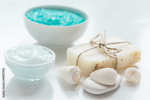 sea salt, soap and body cream on white desk background