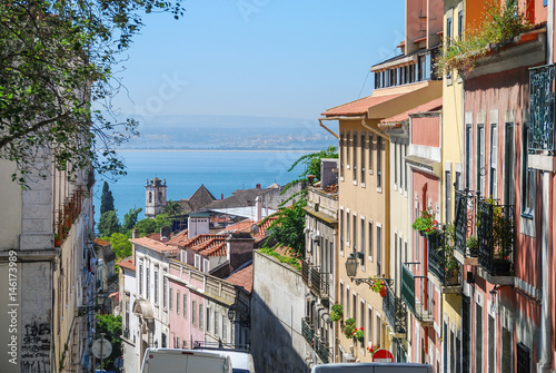 Steep streets of Lisbon with ocean in the background 