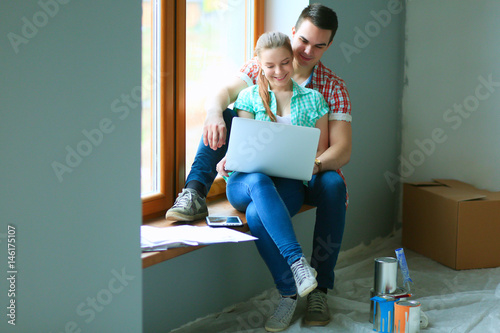 Young couple sitting on floor and calculating about they savings