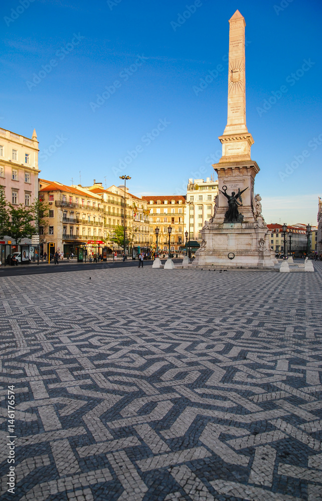 Pedro square in Lisbon, Portugal with monumental obelisk and pavements with ornamental tiles 
