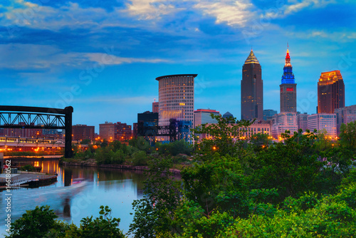 Downtown Cleveland beginning to light up at dusk with the Cuyahoga River winding past photo