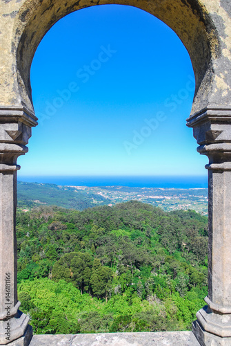 Castle stone portal with panoramic view of forests and ocean in the background