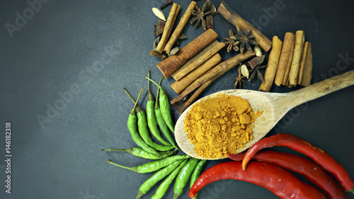 cinnamon, curry powder, green chili, red chili, over a black background, Concept cuisine Asian countries.