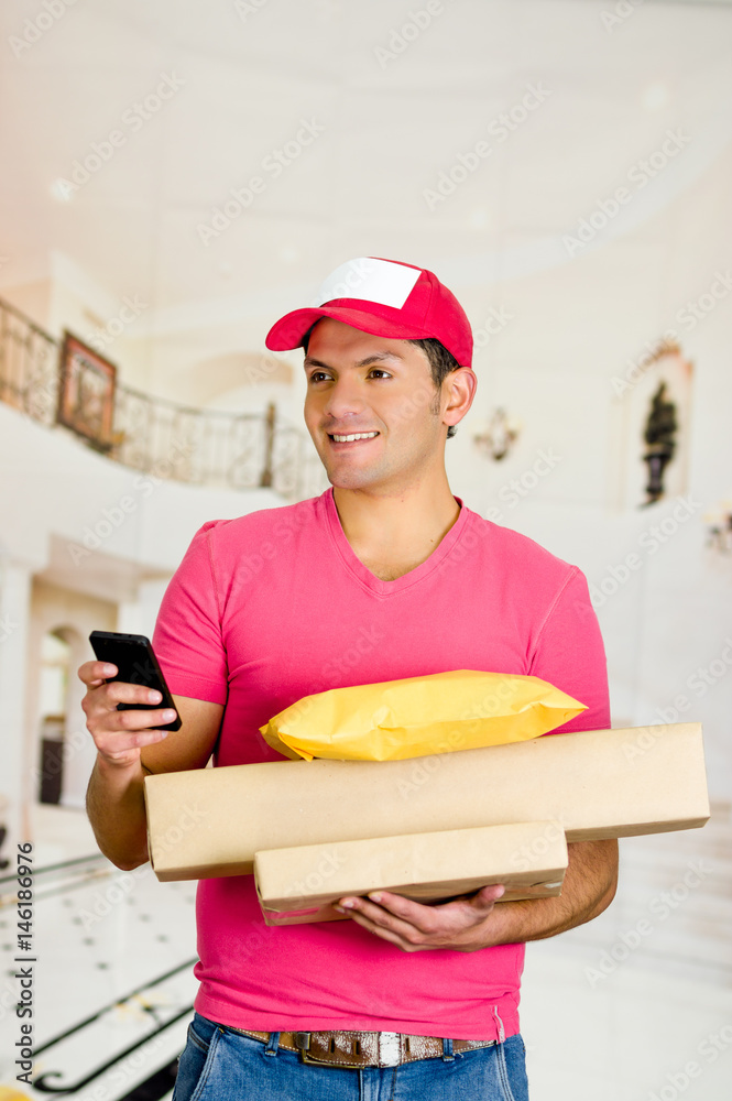 Delivery man in pink uniform holding boxes and documents. Delivery man in pink uniform holding boxes and documents.