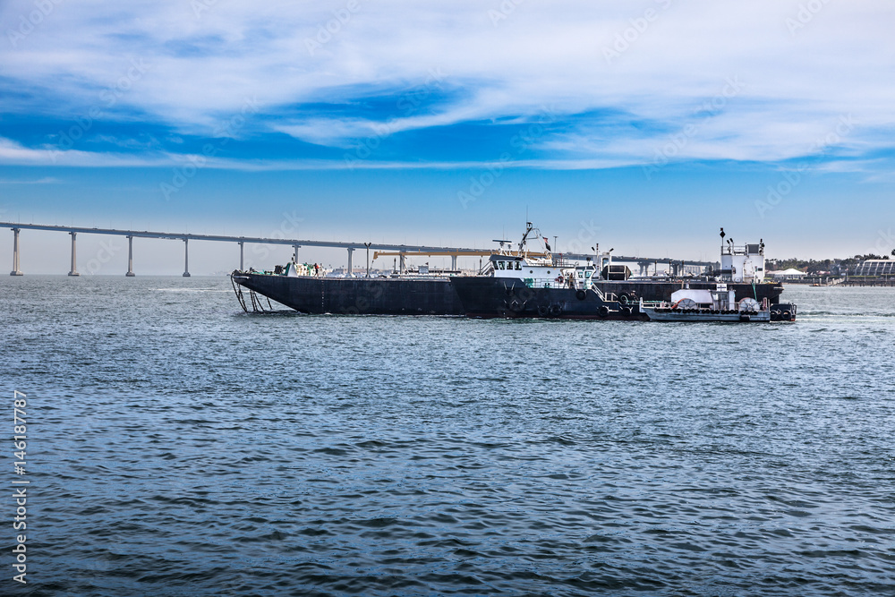 Harbor pilot escorting ship through San Diego Bay into Port of San Diego. Coronado Bay Bridge in the background Harbor pilot escorting ship through San Diego Bay into Port of San Diego. Coronado Bay Bridge in the background