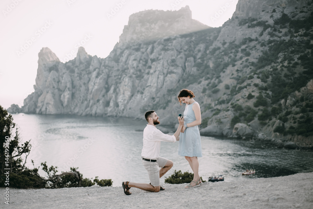 Caucasian man proposing marriage to woman at beach Caucasian man proposing marriage to woman at beach