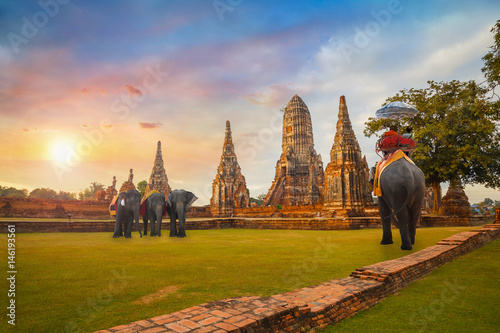 Tourists Ride Elephant at Wat Chaiwatthanaram temple in Ayutthaya Historical Park, a UNESCO world heritage site, Thailand