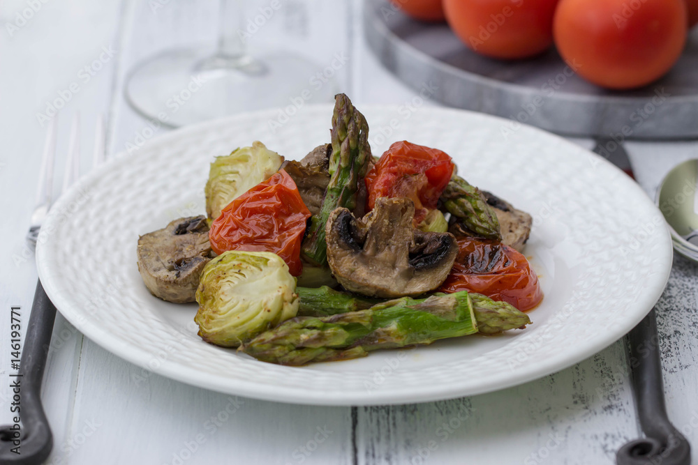 Roasted Vegetables Recipe. Asparagus, Roasted Brussels Sprouts, mushrooms and roasted tomatoes on the white plate. Vegetarian menu. Healthy lifestyle. Roasted Vegetables Recipe. Asparagus, Roasted Brussels Sprouts, mushrooms and roasted tomatoes on the white plate. Vegetarian menu. Healthy lifestyle.
