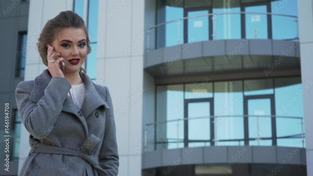 A beautiful young caucasian business woman walking outside office building A beautiful young caucasian business woman walking outside office building