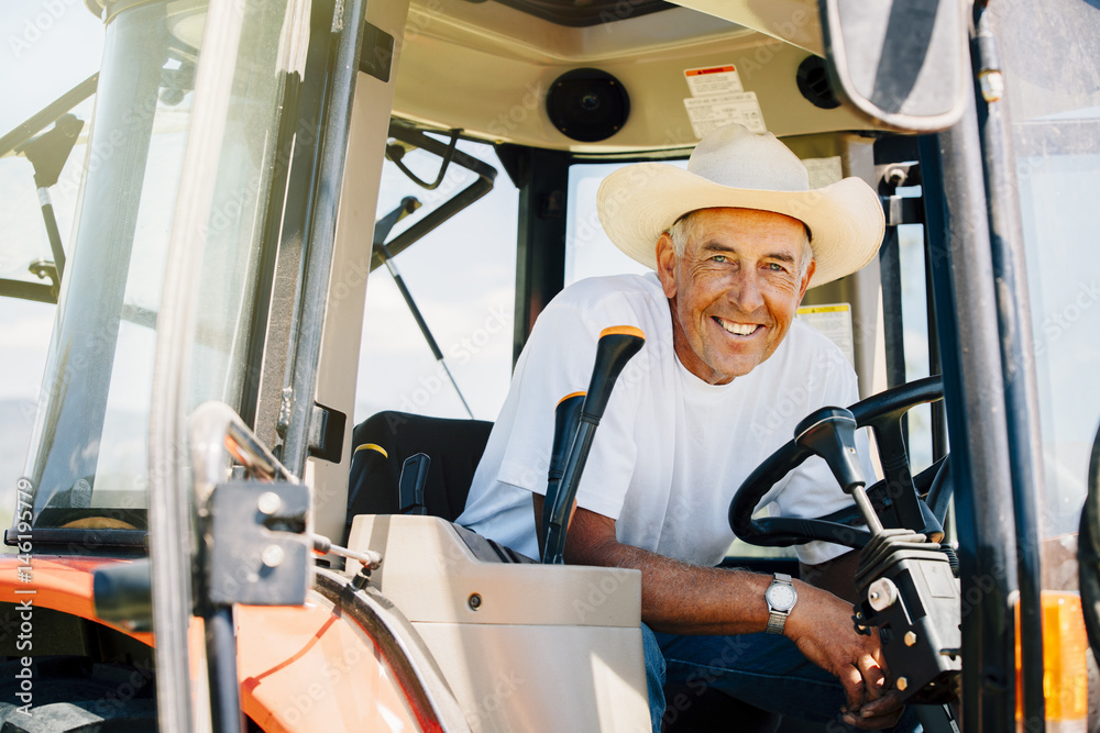 Portrait of smiling Caucasian farmer in tractor Portrait of smiling Caucasian farmer in tractor