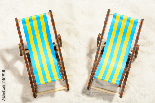Tablou canvas Two sunbeds on the beach: top view
