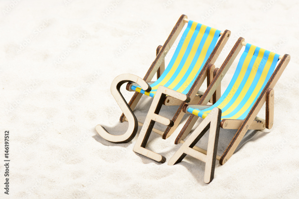 The word SEA and two sunbeds at the beach The word SEA and two sunbeds at the beach