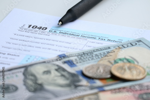Tax form with dollar cash and pen, tax season and accounting concept