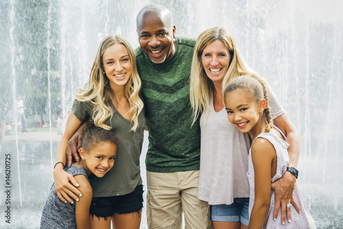Portrait of smiling family standing against fountain photo
