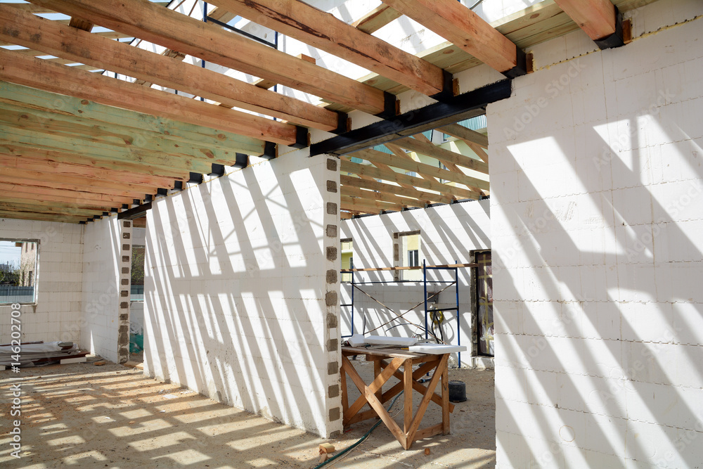 Fototapeta premium The construction of the thermo house. The construction of the thermo house. Wooden frame building. Wooden roof construction. TFB system comprises thermo blocks filled with concrete.