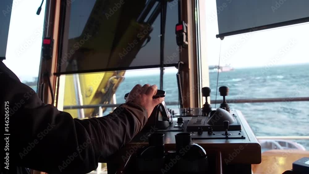Tug master controls motors on bridge. Clear day.