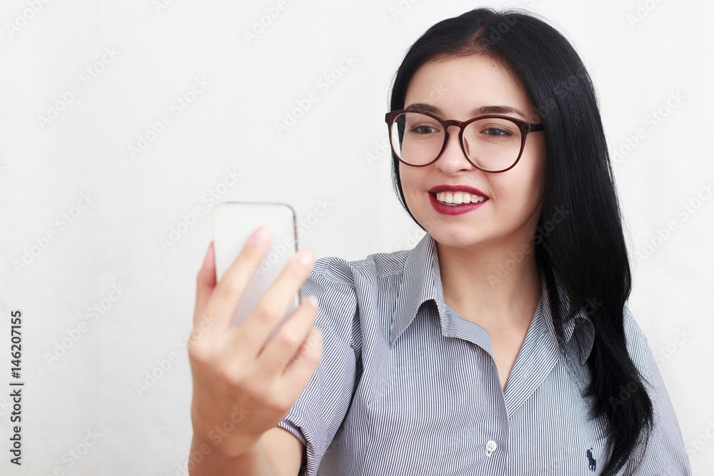 Beautiful woman wearing eyeglasses using a smart phone sitting on a sofa Beautiful woman wearing eyeglasses using a smart phone sitting on a sofa