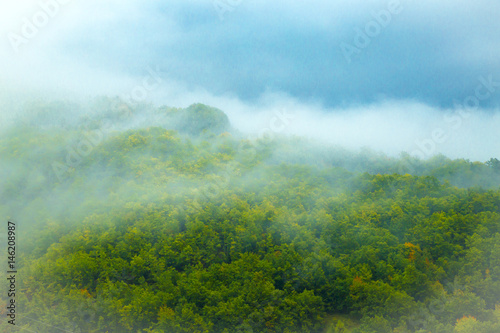 Tranquil panorama of mountain tops in the morning fog and clouds © hriana