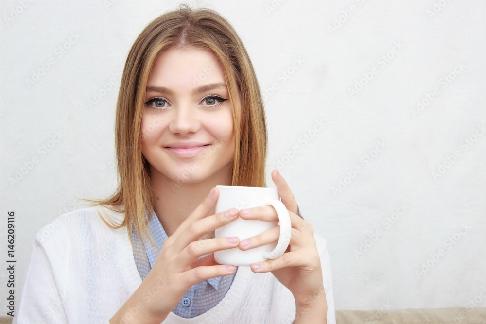woman sitting on couch in her living room and drinking coffee woman sitting on couch in her living room and drinking coffee
