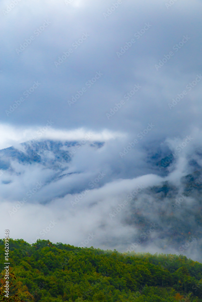 Tranquil panorama of mountain tops in the morning fog and clouds Tranquil panorama of mountain tops in the morning fog and clouds