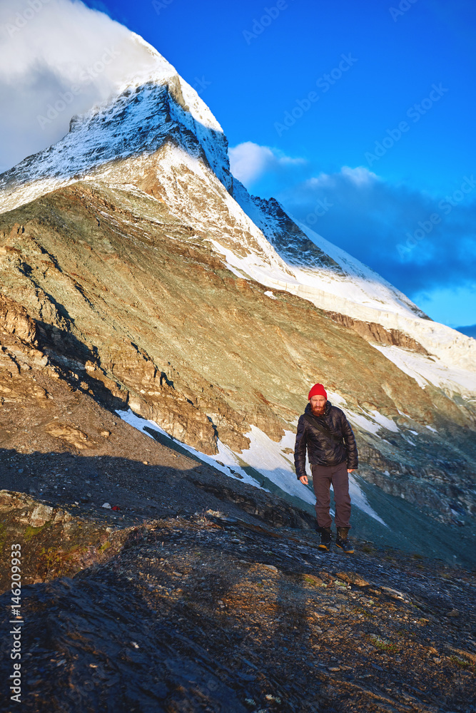 hiker at the top of a pass with Matterhorn mount on background enjoy sunny morning in Alps. Switzerland, Trek near Matterhorn mount.