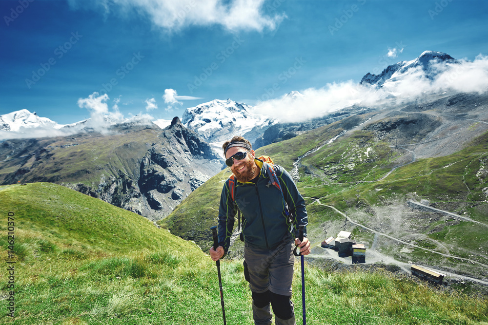 hiker on the trail in the Apls mountains. Trek near Matterhorn mount. Mountain ridge on the background