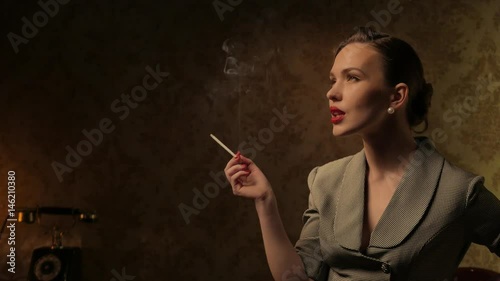 Beautiful woman smoking cigarette in retro interior