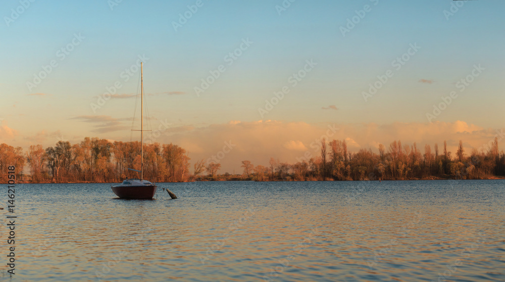 Yacht to the lake in the drift in the rays of the sunset Yacht to the lake in the drift in the rays of the sunset