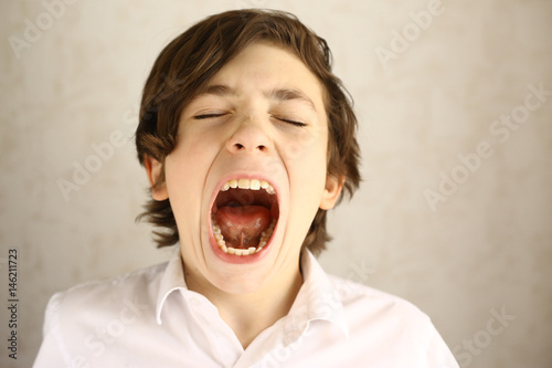 teenager boy yawning open mouth photo