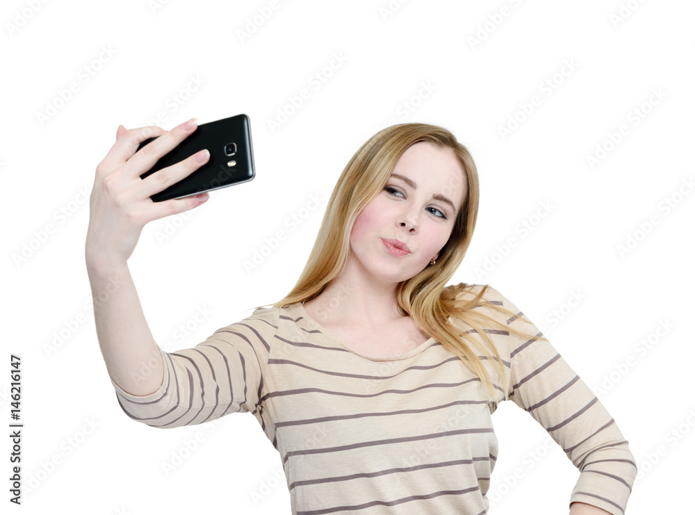 Young girl makes selfie on a smartphone, isolated on white background Young girl makes selfie on a smartphone, isolated on white background