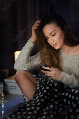 woman using smart phone / laptop at home lying / sitting in bed