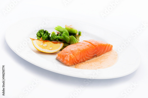 cooked salmon with a side dish of broccoli and Lemon