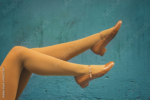 Photos Woman legs with yellow panties and yellow mary jane shoes over a turquoise wall