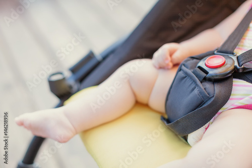 Baby safety protection concept with red button. Newborn baby sleeping in stroller outdoors.