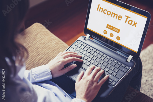 Income tax declaration in a laptop screen. Woman using a laptop computer for income tax calculation.