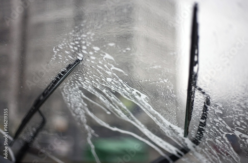 автомобильные дворники чистят лобовое стекло автомобиля в дождливую погоду photo