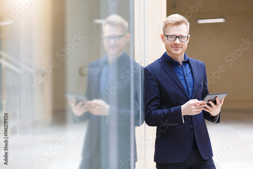 Handsome positive young businessman in modern office