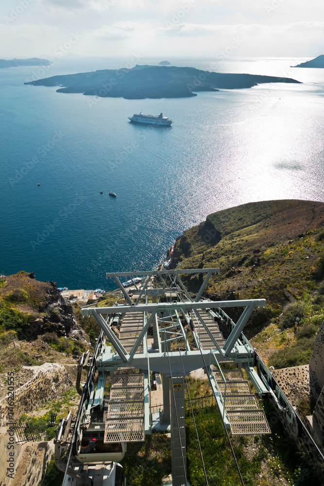 Volcano island with cruisers anchored around, a view from ropeway above port of Fira at Santorini, Greece