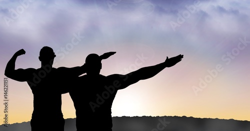 Silhouette men with arms raised during sunset