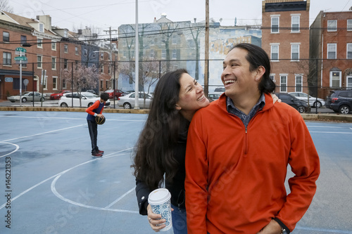 Couple smiling on urban basketball court photo