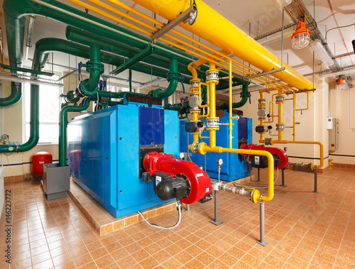 Interior gas boiler house with a lot of industrial boilers, pipes and pumps