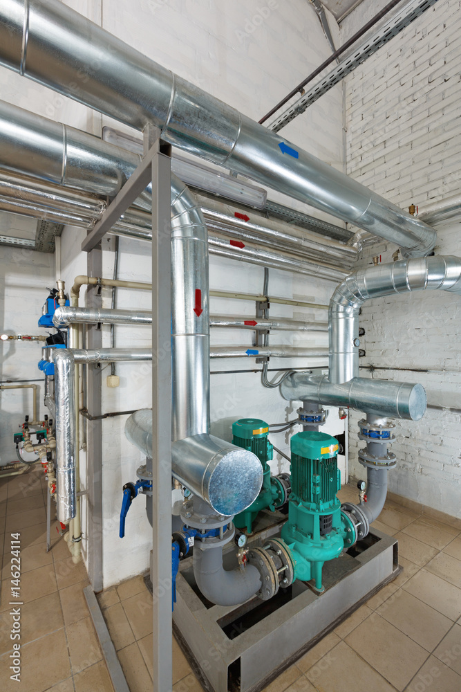 Pumping station in an industrial gas boiler house with a multitude of pipes; Pumps and valves
