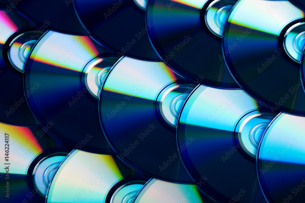 Compact discs background. Several cd dvd blu-ray discs. Optical recordable or rewritable digital data storage. Compact discs background. Several cd dvd blu-ray discs. Optical recordable or rewritable digital data storage.