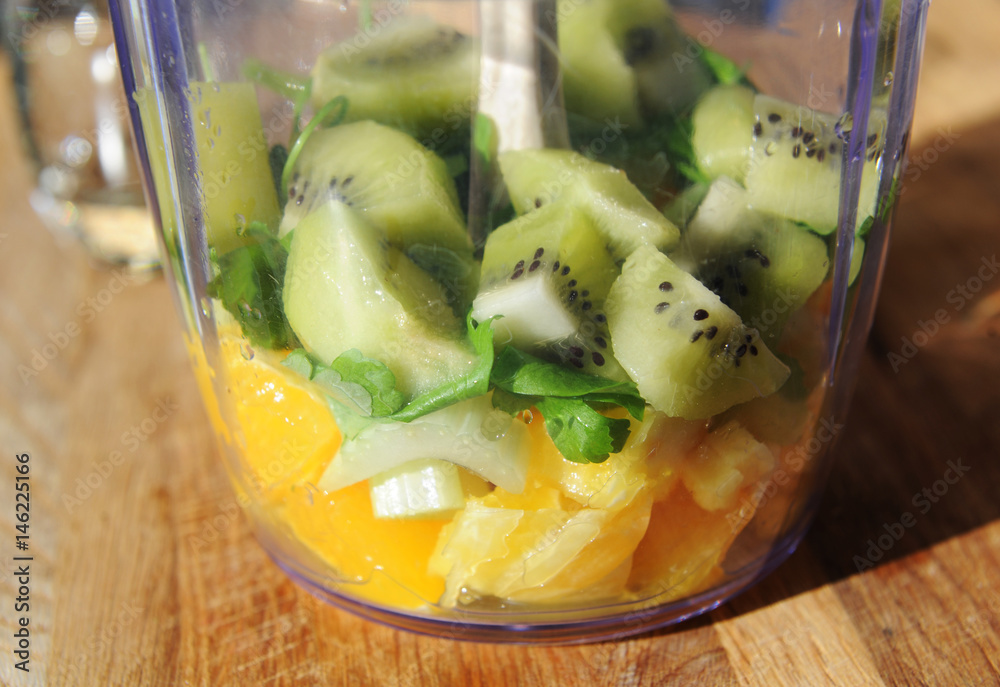 Kiwi, orange, greens in a blender Kiwi, orange, greens in a blender