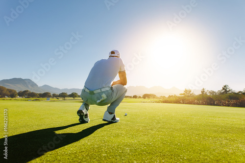 Golf player aiming shot on course