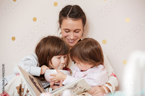 Mother with children reading book