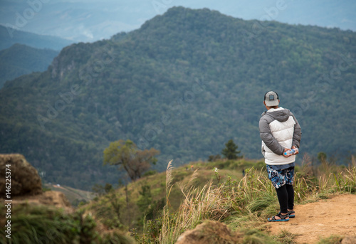 Tourists stand on the viewpoint on the top of the mountain.