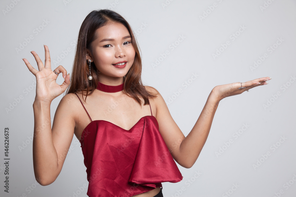 Beautiful young Asian woman show palm hand and OK sign. Beautiful young Asian woman show palm hand and OK sign.