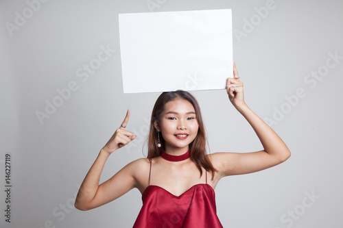 Young Asian woman point to blank sign.